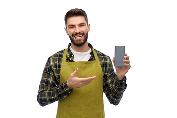 Image showing happy male gardener or farmer with smartphone