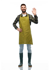 Image showing happy male gardener or farmer in apron waving hand