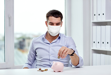 Image showing businessman in mask with piggy bank and money