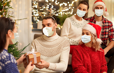 Image showing friends in masks celebrating christmas at home