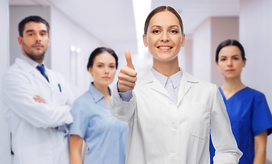 Image showing doctor with colleagues shows thumbs up at hospital