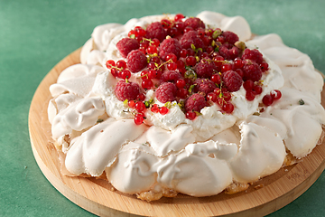 Image showing pavlova meringue cake with berries on wooden board