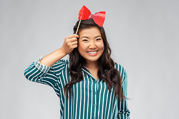 Image showing happy asian woman with red party bow