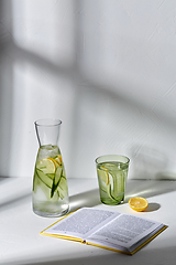 Image showing glass of water with lemon and cucumber and book