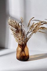 Image showing decorative dried flowers in brown glass vase