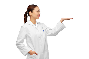 Image showing asian female doctor holding something on hand