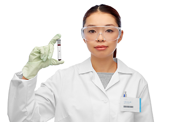 Image showing asian female doctor holding beaker with blood test