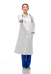 Image showing happy asian female doctor pointing to camera