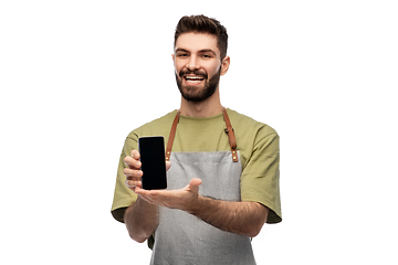 Image showing happy smiling barman in apron showing smartphone