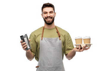 Image showing happy waiter with takeout coffee cups and tumbler