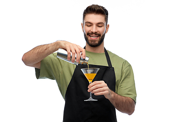 Image showing happy barman with shaker and glass preparing drink