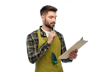 Image showing male gardener with clipboard and pen thinking