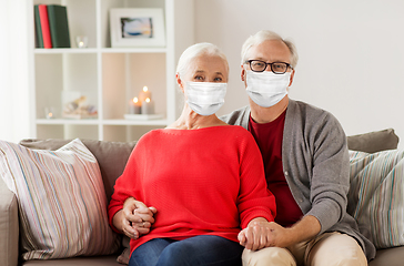 Image showing senior couple in masks on christmas at home