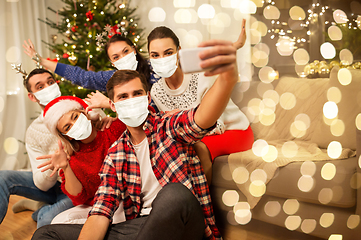 Image showing friends in masks taking selfie at christmas party