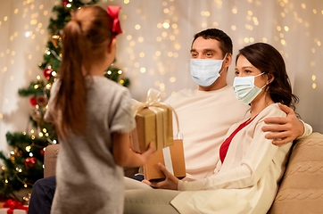 Image showing family in masks with christmas presents at home