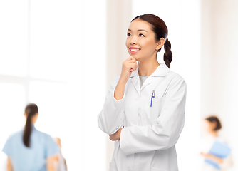 Image showing thinking asian female doctor at hospital