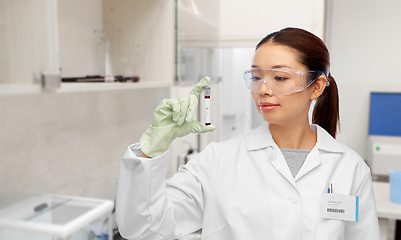 Image showing asian female doctor holding beaker with blood test