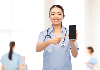 Image showing asian female nurse with smartphone at hospital