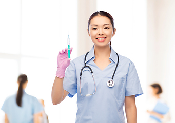 Image showing happy asian female nurse with medicine and syringe