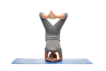 Image showing woman making yoga in headstand pose on mat