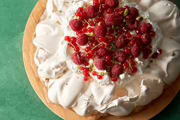 Image showing pavlova meringue cake with berries on wooden board