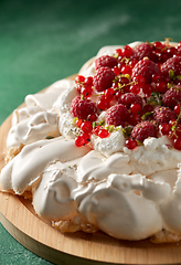 Image showing pavlova meringue cake with berries on wooden board