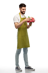 Image showing smiling male gardener with bunch of peony flowers