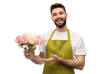 Image showing smiling male gardener with bunch of peony flowers