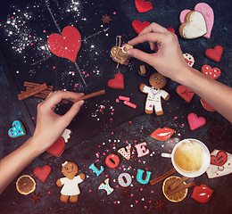 Image showing Female hands decorating love gingerbread composition