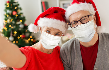 Image showing senior couple in masks taking christmas selfie