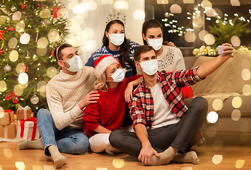 Image showing friends in masks taking selfie at christmas party