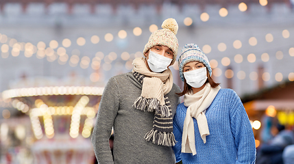 Image showing couple in masks and winter clothes on christmas