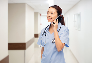 Image showing asian nurse calling on smartphone at hospital