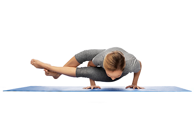 Image showing woman making yoga in handstand on mat