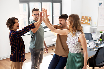 Image showing happy business team making high five at office