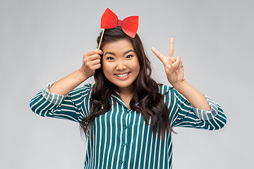 Image showing happy asian woman with red party bow