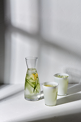 Image showing glasses with lemon water and cucumber on table