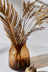 Image showing decorative dried flowers in glass vase and pumpkin