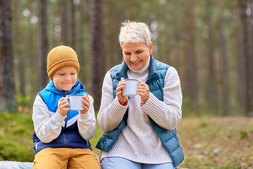 Image showing grandmother with grandson drinking tea in forest