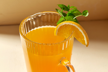 Image showing close up of jug with orange juice and peppermint