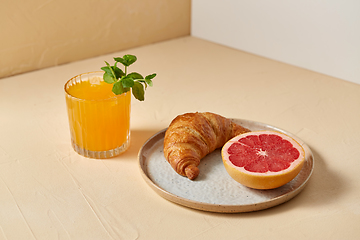 Image showing orange juice, croissant and grapefruit on plate