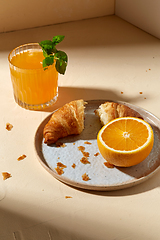 Image showing glass of orange juice and croissant on plate