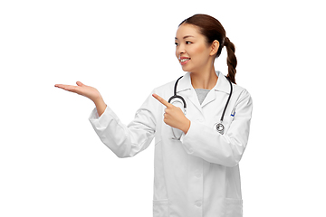 Image showing asian female doctor holding something on hand