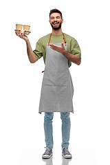 Image showing happy smiling barman in apron with takeaway coffee