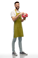 Image showing smiling male gardener with bunch of peony flowers