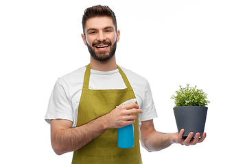 Image showing happy smiling male gardener moisturizing flower