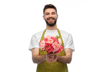 Image showing smiling male gardener with bunch of peony flowers