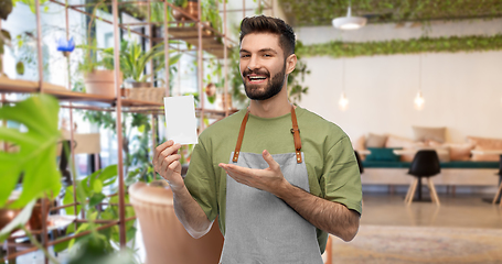 Image showing smiling barman in apron with bill at restaurant