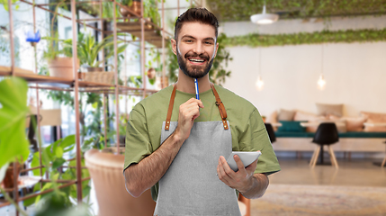 Image showing smiling waiter with pen and notepad at restaurant