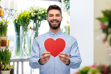 Image showing happy smiling man with red heart at flower shop